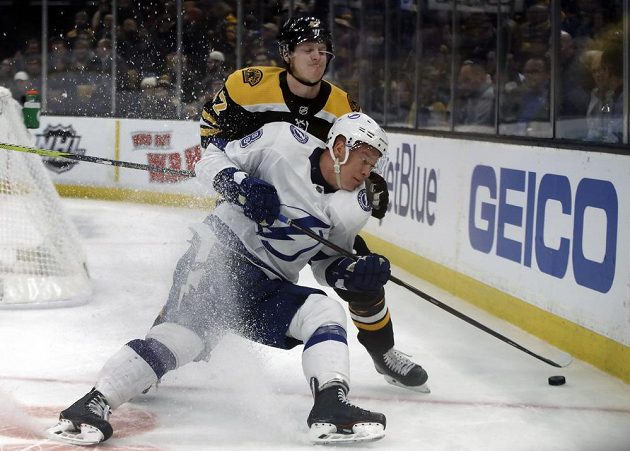 Útočník Tampy Bay Ondřej Palát čelí ataku bostonského obránce Toreyho Kruga (47) v utkání NHL.