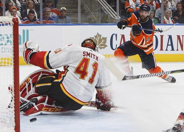 Gólman Calgary Flames Mike Smith má puk za svými zády po ráně Patricka Maroona z Edmontonu