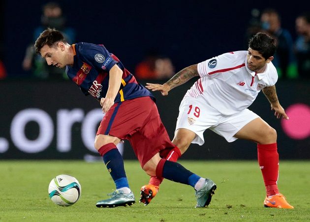 Záložník Sevilly Éver Banega (vpravo) se pokouší zastavit Lionela Messiho z Barcelony.
