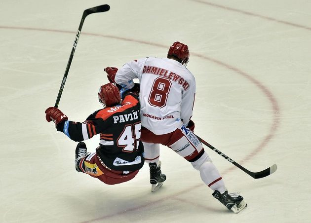 Útočník Třince Aron Chmielewski sráží v extraligovém utkání hradeckého obránce Filipa Pavlíka.