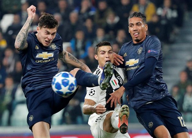 Hvězda Juventusu Cristiano Ronaldo v obležení soupeřů z Manchesteru United v utkání Ligy mistrů.