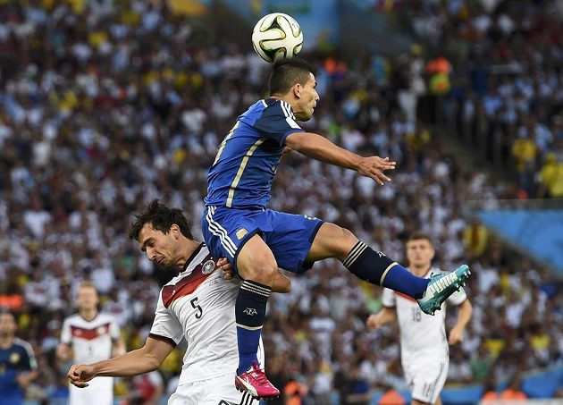Argentinský útočník Sergio Agüero (ve výskoku) v souboji s německým stoperem Matsem Hummelsem.
