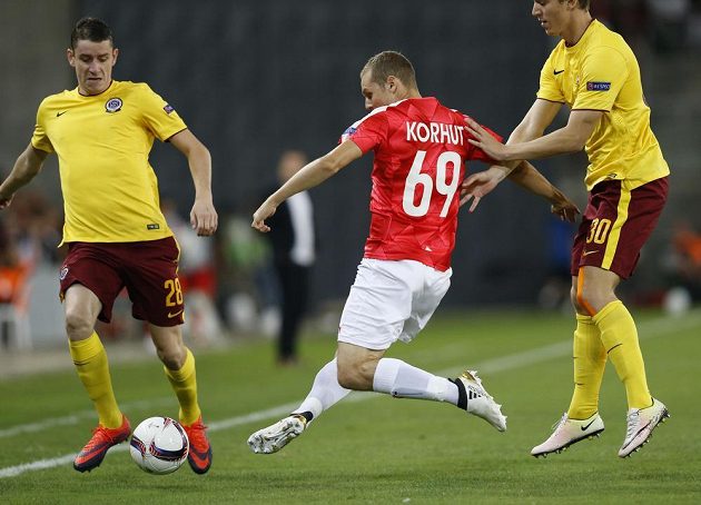 Fotbalista Hapoelu Beer Ševa Mihaly Korhut střílí mezi dvojicí sparťanů Ondřejem Zahustelem (vlevo) a Lukášem Julišem v utkání Evropské ligy.