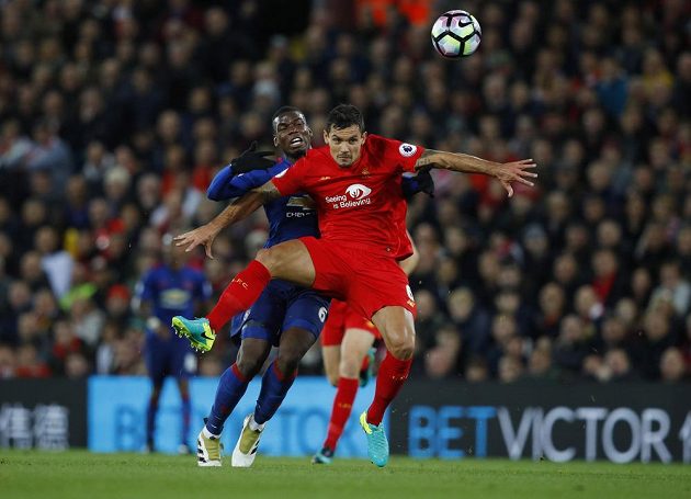Stoper Liverpoolu Dejan Lovren hlavičkuje míč před Paulem Pogbou z Manchesteru United.