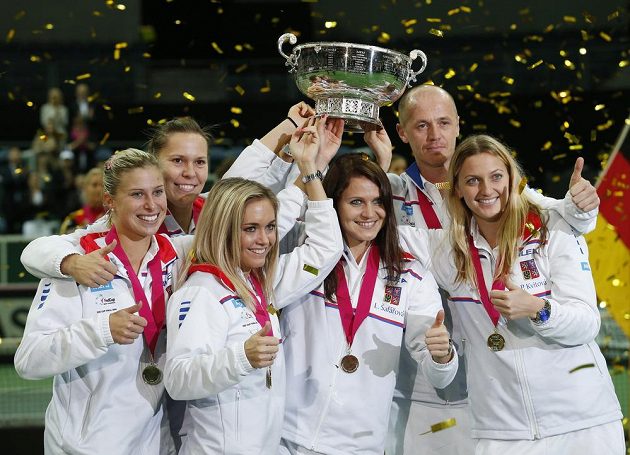 Český tým (zleva) Andrea Hlaváčková, Lucie Hradecká, Klára Koukalová, Lucie Šafářová, nehrající kapitán Petr Pála a Petra Kvitová s trofejí.