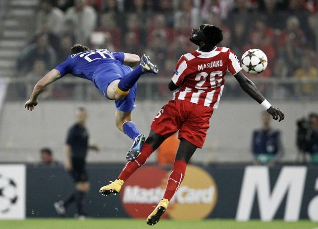 Stephan Lichtsteiner (vlevo) z Juventusu ve vzdušném souboji s Arthurem Masuakuem z Olympiakosu v utkání Ligy mistrů.