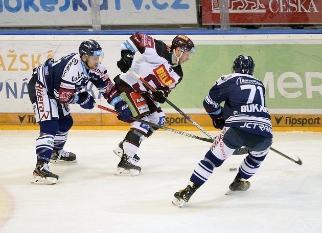 Jan Hruška z Vítkovic, Matúš Sukeľ ze Sparty a Roberts Bukarts z Vítkovic během extraligového utkání.