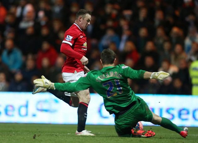 Útočník Manchesteru United Wayne Rooney v souboji s brankářem Prestonu Thorstenem Stuckmannem.