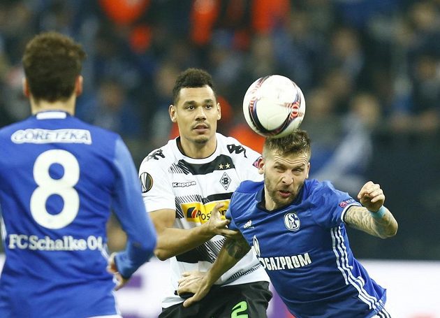 Guido Burgstaller (vpravo) ze Schalke hlavičkuje před dotířajícím Timothee Kolodziejczakem z Mönchengladbachu. Souboj sleduje Leon Goretzka.