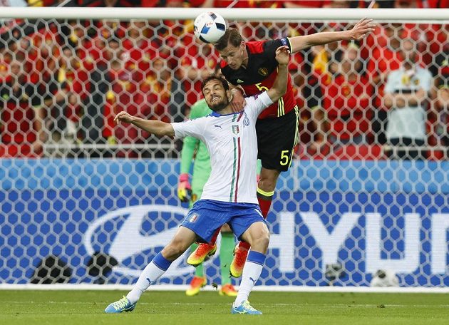 Belgičan Jan Vertonghen (vpravo) odhlavičkovává míč před Italem Marco Parolem.