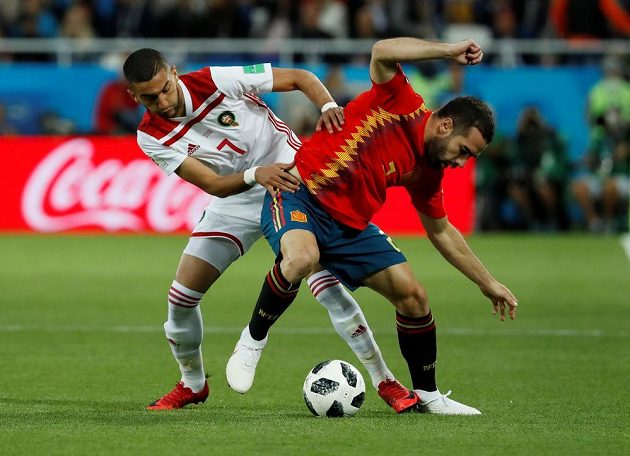 Španělský fotbalista Dani Carvajal si kryje míč před dotírajícím Maročanem v utkání mistrovství světa.