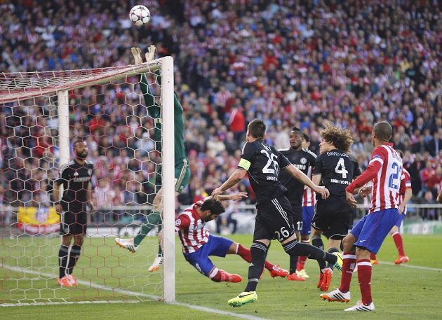 Petr Čech zasahuje proti rohovému kopu v úvodním semifinále Ligy mistrů proti Atlétiku Madrid. Po kolizi s hráčem soupeře si poranil ruku a musel střídat