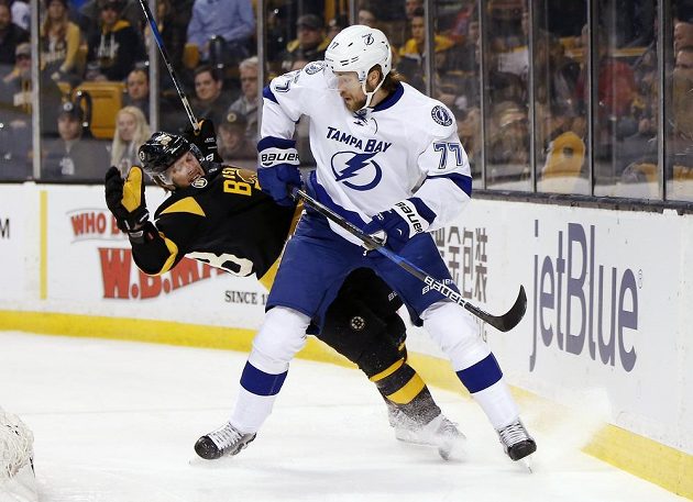 Český útočník Bostonu David Pastrňák se poroučí k zemi po souboji se Švédem Victorem Hedmanem z Tampy Bay Lightning v utkání NHL. Tampa vyhrála zápas 6:3.