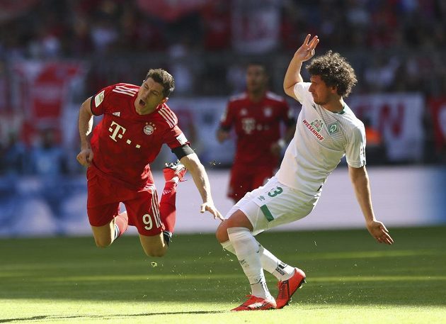 Útočník Bayernu Robert Lewandowski letí vzduchem po faulu obránce Miloše Veljkoviče z Werderu Brémy.