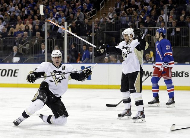 Útočníci Pittsburghu Jevgenij Malkin (vlevo) a Chris Kunitz (uprostřed) se radují z gólu proti New Yorku Rangers. Vpravo je smutný forvard Jezdců Brian Boyle.