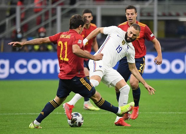 Španělský fotbalista Mikel Oyarzabal a francouszký hráč Karim Benzema v souboji o míč.