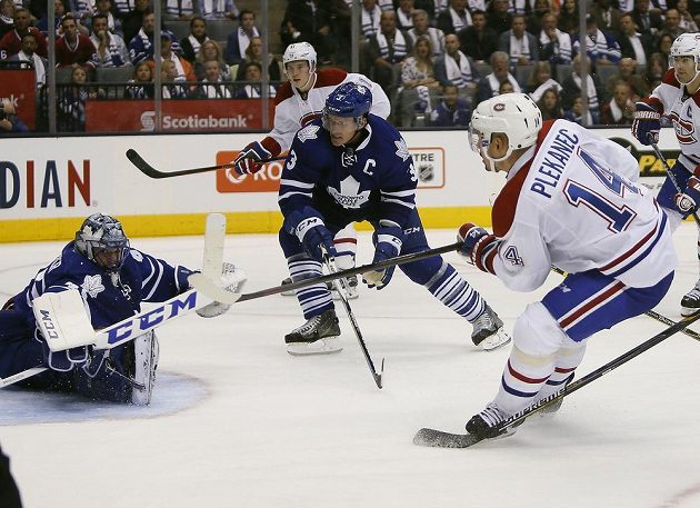 Tomáš Plekanec střílí na branku Jonathana Berniera, kapitán Toronta Dion Phaneuf už zasáhnout nestačil.