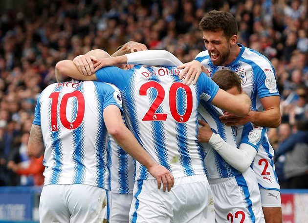 Fotbalisté týmu Huddersfield Town v euforii. Laurent Depoitre slaví svůj druhý gól v síti favorizovaného Manchesteru United se spoluhráči , kterými jsou Aaron Mooy, Tommy Smith. Huddersfield vyhrál 2:1.