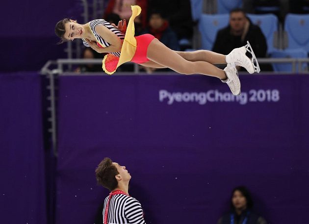 Anna Dušková ve vzduchu během volné jízdy sportovních dvojic olympijského závodu v Pchjongčchangu. Připavený zachytit svou parťačku je Martin Bidař.