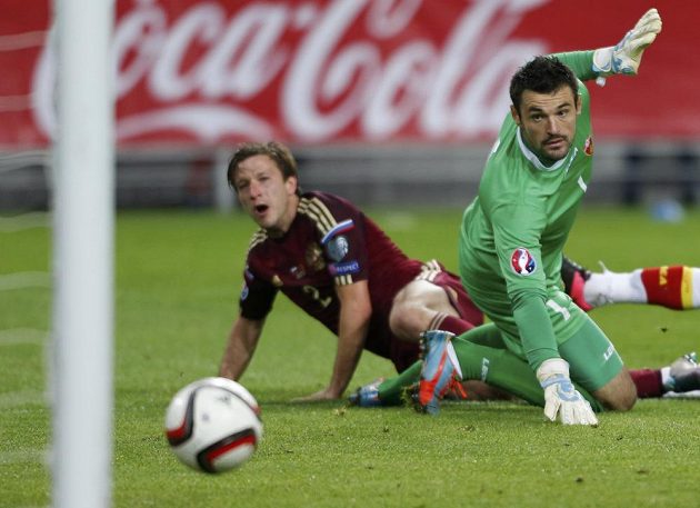 Černohorský gólman Milan Mijatovič sleduje míč, který míří do jeho branky po střele Rusa Olega Kuzmina (vlevo).