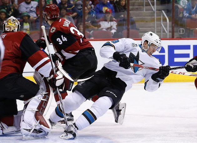 Útočník San Jose Tomáš Hertl (v bílém dresu) během utkání v Arizoně. Vlevo je obránce Coyotes Klas Dahlbeck.