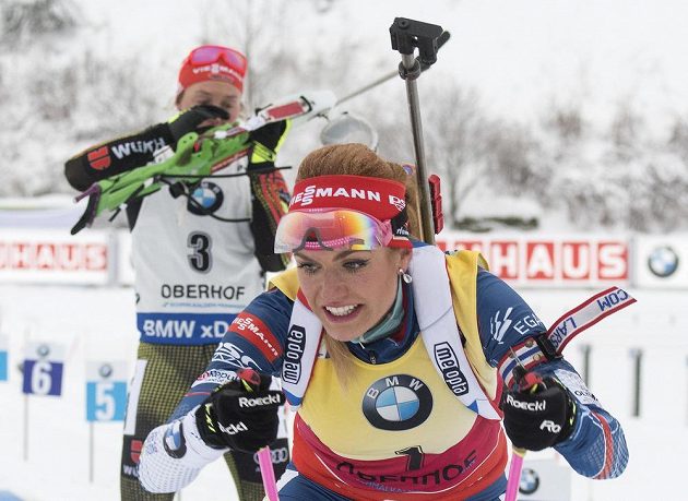 Gabriela Koukalová odjíždí po závěrečné střelbě, její německá soupeřka Laura Dahlmeierová se teprve chystá pálit.