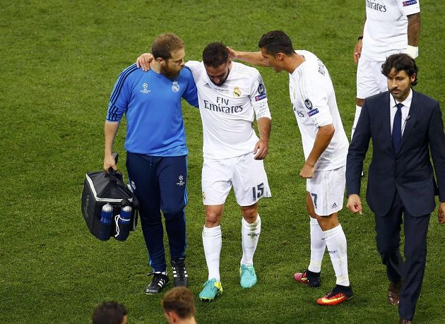 Nejde to. Zraněný fotbalista Realu Dani Carvajal (uprostřed) musí kvůli zranění opustit trávní San Sira při finále Ligy mistrů. Po cestě jej utěšuje hvězdný Cristiano Ronaldo.