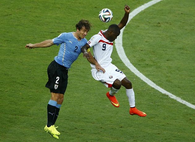Kapitán uruguayského týmu Diego Lugano (vlevo) v hlavičkovém souboji s Kostaričanem Joelem Campbellem.