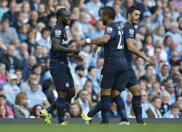 Fotbalisté West Hamu (zleva) Victor Moses a Dimitri Payet se radují z gólu proti Manchesteru City.