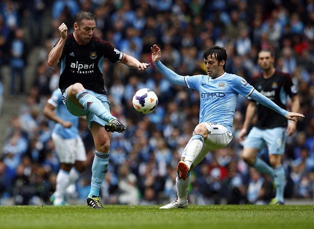Záložník Manchesteru City David Silva (vpravo) bojuje o míč s Kevinem Nolanem z West Hamu United.