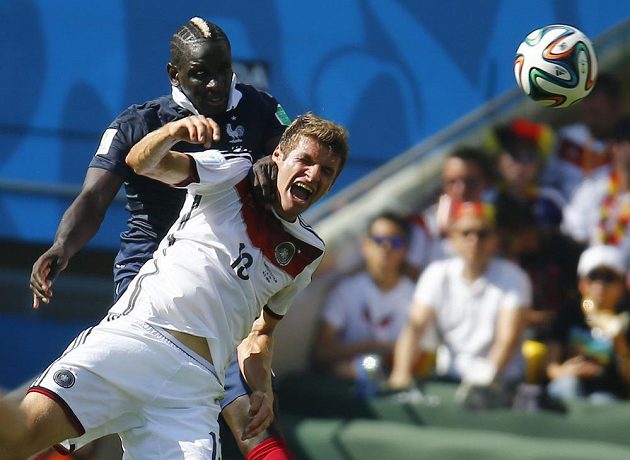 Francouzský stoper Mamadou Sakho (vzadu) v hlavičkovém souboji s Němcem Thomasem Müllerem.