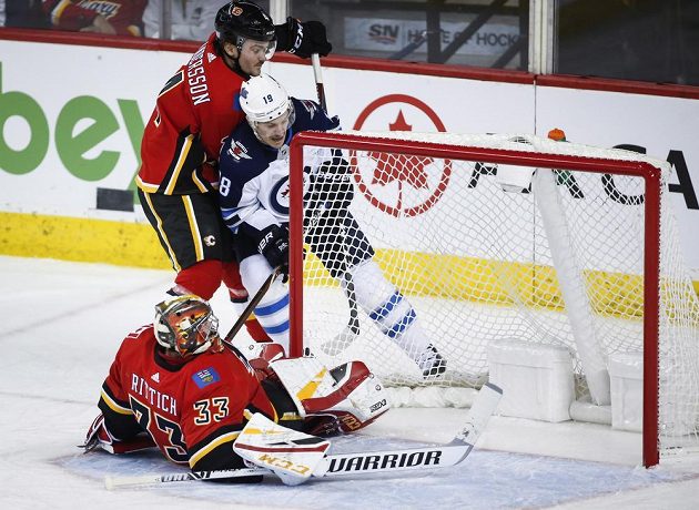 Český gólman Calgary David Rittich se ocitl na ledové ploše poté, co jej atakoval Bryan Little z týmu Winnipeg Jets v utkání NHL.