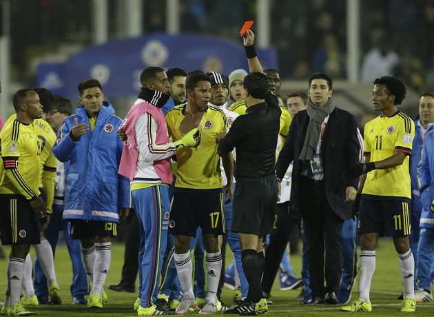 Kolumbijec Carlos Bacca dostává červenou kartu od sudího Enriqueho Ossese po utkání s Brazílií.