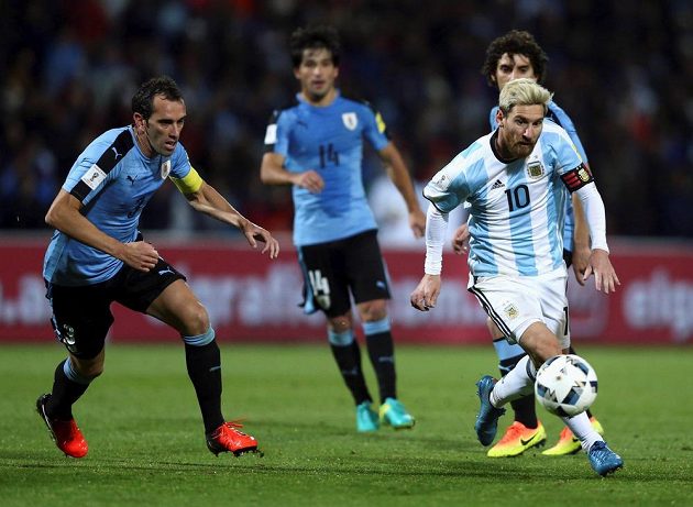 Argentinec Lionel Messi (vpravo) a Diego Godín z Uruguaye v utkání kvalifikace MS.