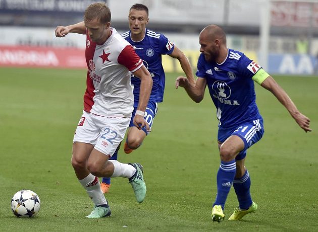 Fotbalista Slavie Tomáš Souček se snaží uniknout olomouckým hráčům Šimonu Faltovi a Michalu Vepřekovi v utkání úvodního kola nejvyšší soutěže.