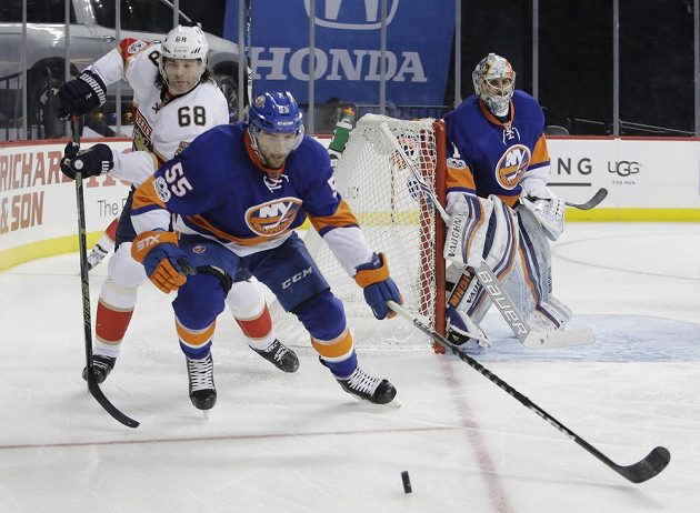 Útočník Floridy Jaromír Jágr (vlevo) bojuje o puk s Johnnym Boychukem z týmu New York Islanders. Přihlíží gólman Ostrovanů Thomas Greiss.