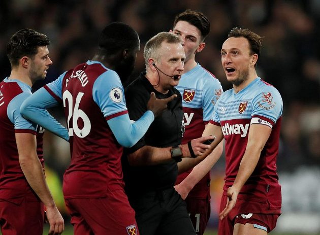 Fotbalisté West Hamu United diskutují s rozhodčím během utkání Premier League proti Liverpoolu.