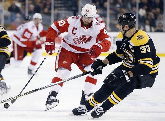 Slovenský obránce Bostonu Bruins Zdeno Chára (33) se snaží zastavit Henrika Zetterberga z Detroitu v utkání NHL.