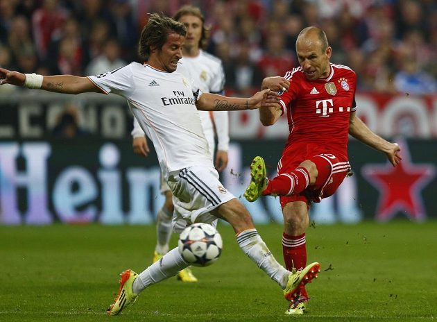 Střelecký pokus tvůrce hry Bayernu Arjena Robbena se snaží zblokovat Fabio Coentrao (vlevo) z Realu Madrid.