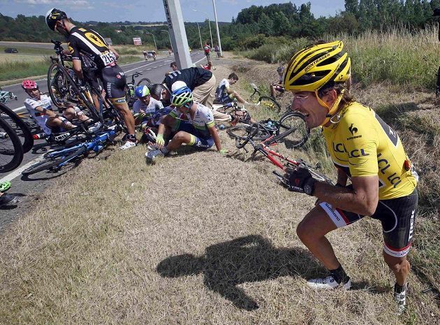 Potlučený Fabian Cancellara (vpravo) se sápe z příkopu po hromadném pádu ve třetí etapě Tour. Švýcar a dosavadní držitel žlutého trikotu posléze ze závodu odstoupil.