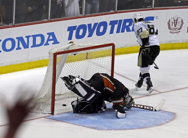 Gólman Anaheimu Jonas Hiller marně hledá puk ve výstroji po nájezdu kapitána Pittsburghu Sidneyho Crosbyho.