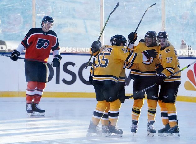 Hokejisté Bostonu Bruins slaví. Český kanonýr David Pastrňák (88) se raduje z gólu v síti Philadelphie, k přesné trefě gratulují obránce Jeremy Lauzon (55) a útočník Patrice Bergeron (37).