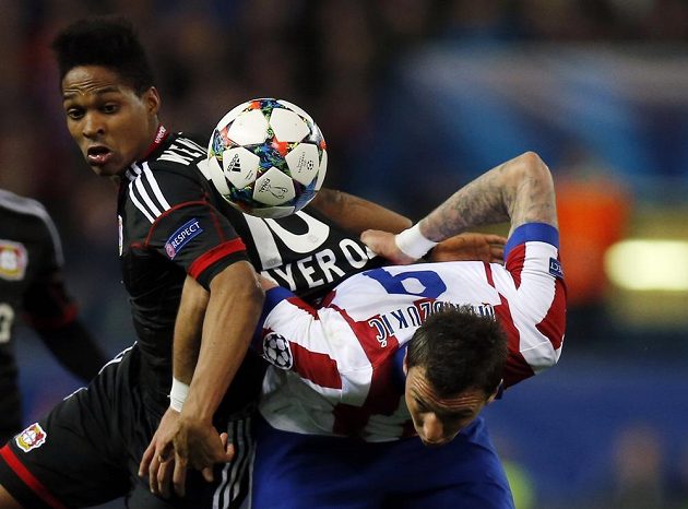 Wendell z Leverkusenu (vlevo) a útočník Atlétika Madrid Mario Mandzukič v odvetném osmifinálovém zápase Ligy mistrů.