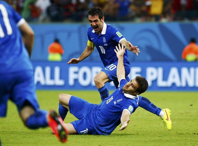 Řecký obránce Sokratis Papastathopoulos (dole) jásá se spoluhráčem Giorgosem Karagounisem nad vyrovnávacím gólem proti Kostarice v osmifinále MS.