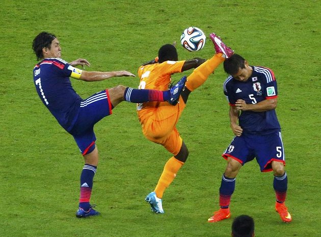 Japonci Endo a Nagatomo se pokouší připravit o míč Ya Konana z Pobřeží slonoviny.