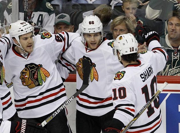 Patrick Kane (88) po vstřelení branky, která Chicagu na ledě Minnesoty zajistila výhru ve třetím zápase druhého kola play off NHL. Gratulují mu Andrew Shaw (vlevo) a Patrick Sharp.