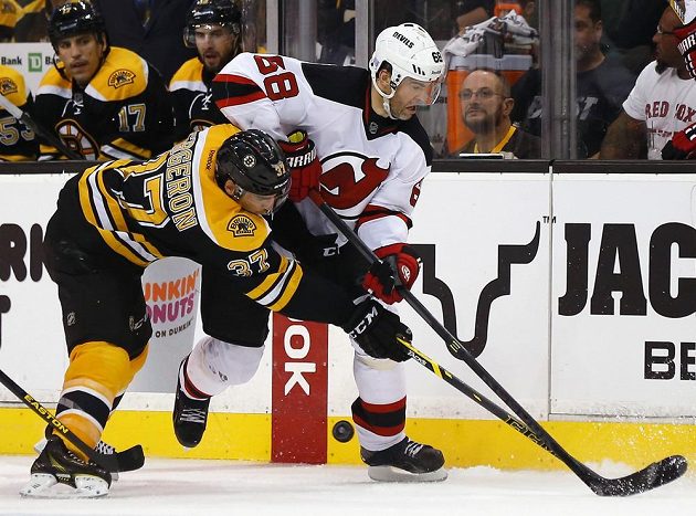 Jaromír Jágr (68) v dresu New Jersey v souboji s bostonským Patricem Bergeronem (37).