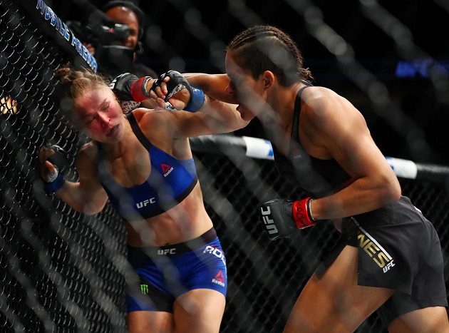 Ronda Rouseyová (vlevo) během zápasu s Brazilkou Amandou Nuněsovou inkasovala řadu tvrdých úderů.