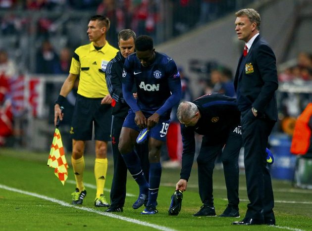 Forvard Manchesteru United Danny Welbeck (19) si přezouvá kopačky. Vpravo je kouč David Moyes.