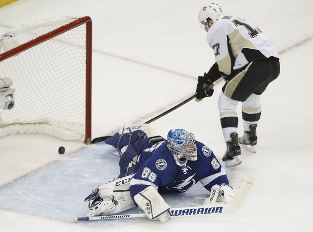 Brankář Tampy Andrej Vasilevskij se marně natahuje po blafáku útočníka Pittsburghu Bryana Rusta.